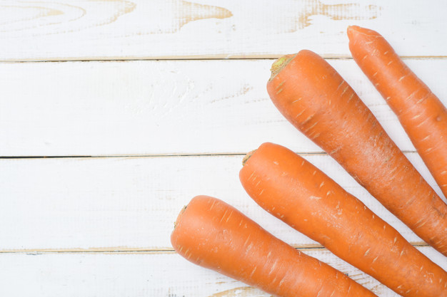 Carrot on white wooden table. Premium Photo
